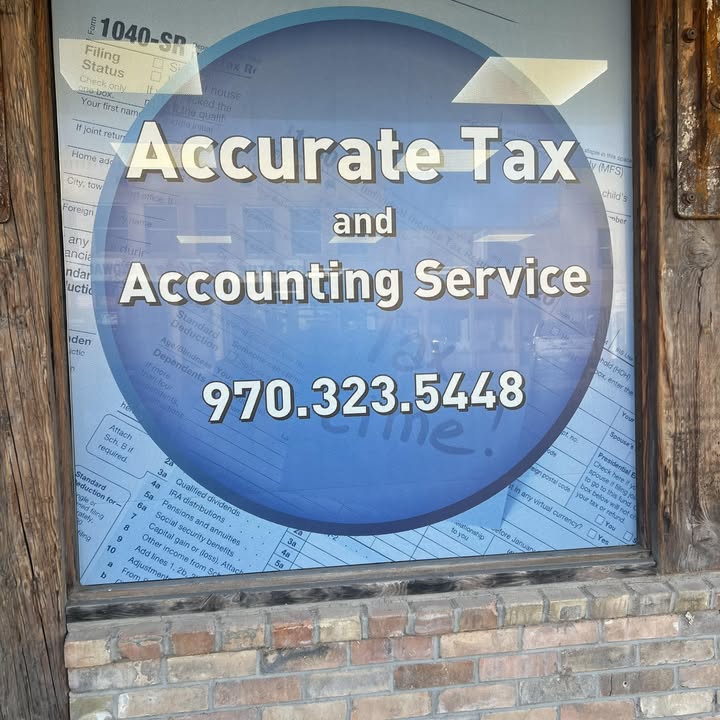 Window signage reading Accurate Tax and Accounting Service, 970.323.5448, on Main Street